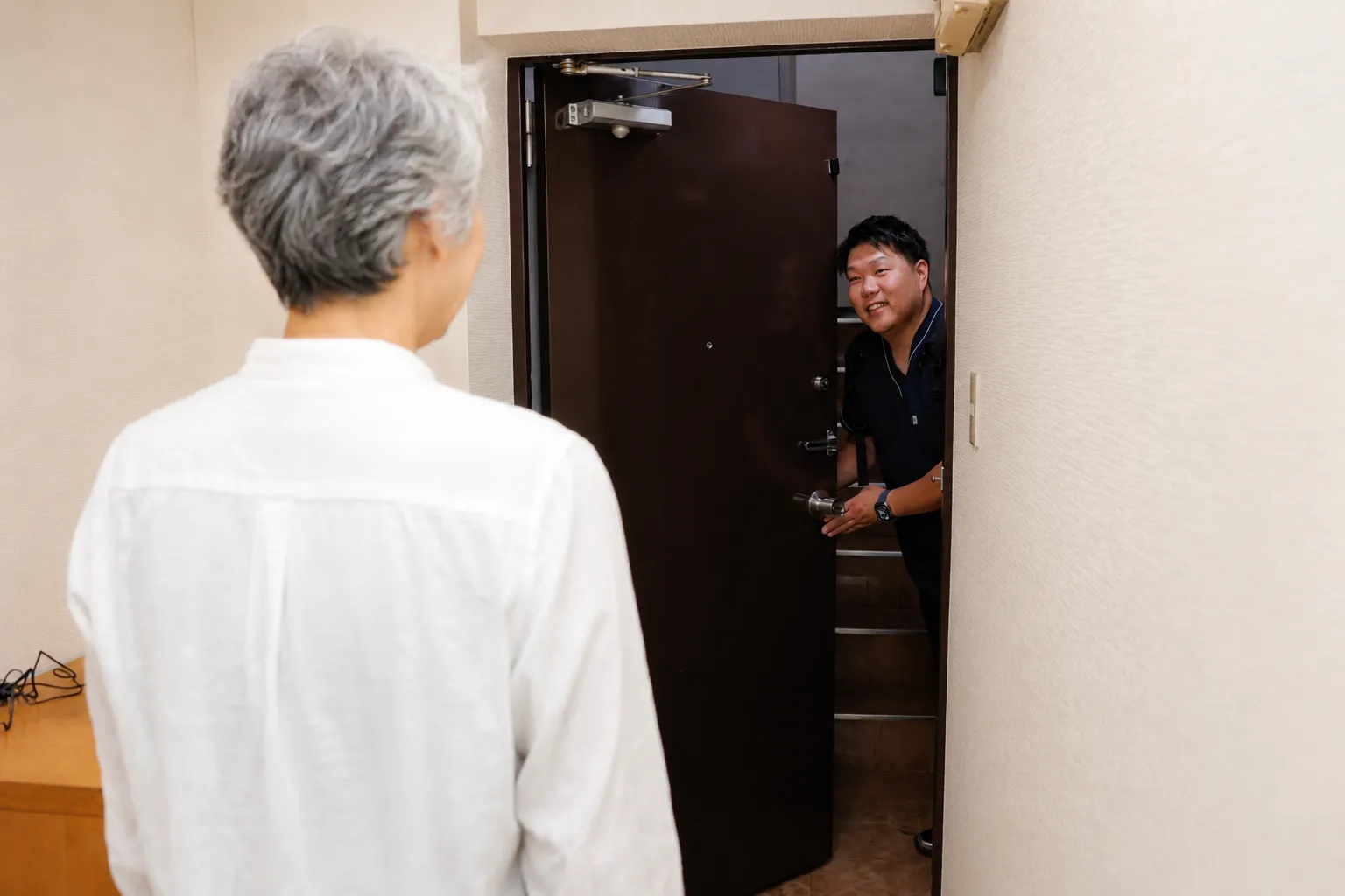 玄関先でご利用者を笑顔で出迎える院長